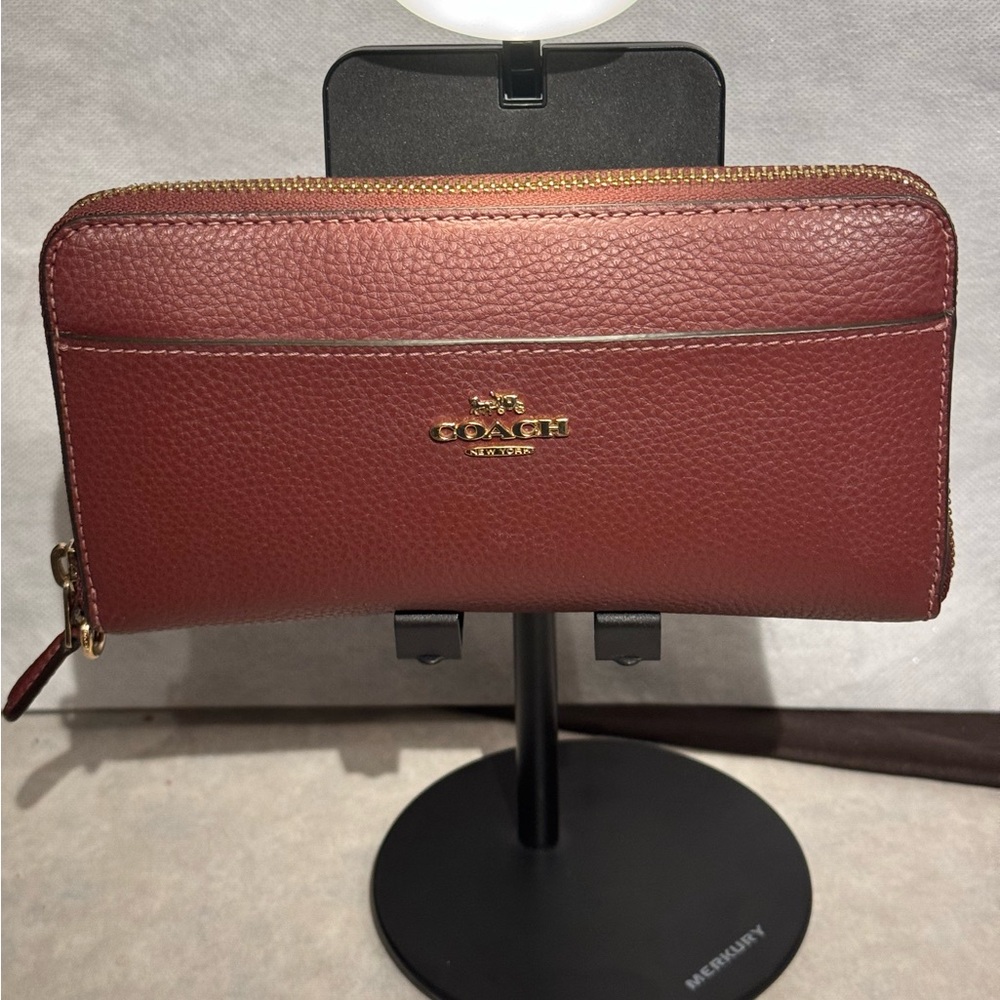 Coach Accordion Zip Wallet in a Plum color with gold tone hardware.